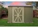 The backyard shed has a white roof and a wooden door painted with a lighter shade of green at 7813 N 17Th Dr, Phoenix, AZ 85021