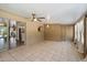Neutral sunroom features tile flooring, a ceiling fan, glass doors, and views to the kitchen and backyard at 7813 N 17Th Dr, Phoenix, AZ 85021