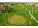 Scenic aerial view of a lush golf course featuring manicured greens, palm trees, and winding paths at 8037 E Navarro Ave, Mesa, AZ 85209