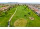 Aerial view of the golf course with lush green fairways, palm trees, and golfers enjoying a sunny day near the mountains at 8037 E Navarro Ave, Mesa, AZ 85209