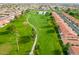 Aerial view of a lush golf course winding through a residential area, showcasing mature trees and manicured greens at 8037 E Navarro Ave, Mesa, AZ 85209