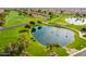 Aerial view of a tranquil pond with fountain on the golf course, surrounded by lush greenery and mature trees at 8037 E Navarro Ave, Mesa, AZ 85209