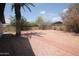 View of gravel and walkway in backyard featuring a tall palm tree at 8310 N 49Th Ave, Glendale, AZ 85302