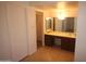 Hallway view to vanity with mirrors and cabinetry in a well-lit bathroom at 8310 N 49Th Ave, Glendale, AZ 85302