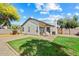 Well-kept backyard with grass, gravel and patio area with porch swing for relaxing outdoors at 8335 W Pershing Ave, Peoria, AZ 85381