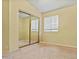 Bedroom with carpet, a large window, and a mirrored closet at 8335 W Pershing Ave, Peoria, AZ 85381