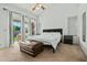 Bright bedroom with patio access, ceiling fan, and large cushioned ottoman at 8335 W Pershing Ave, Peoria, AZ 85381