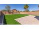 Backyard featuring synthetic grass, stone-paved patio, and secure block wall for privacy at 852 E Mountain View Rd # 18, San Tan Valley, AZ 85143