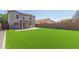 Large, green synthetic lawn and block wall ensure privacy in this home's backyard at 852 E Mountain View Rd # 18, San Tan Valley, AZ 85143