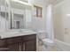 Bathroom featuring a sink with a dark cabinet, a toilet, a shower, and a mirror at 852 E Mountain View Rd # 18, San Tan Valley, AZ 85143