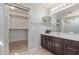 Bathroom with dark wood vanity, large closet, shower and ample lighting at 852 E Mountain View Rd # 18, San Tan Valley, AZ 85143