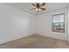 Bedroom with neutral carpet, a ceiling fan, and a window overlooking the neighborhood at 852 E Mountain View Rd # 18, San Tan Valley, AZ 85143