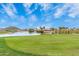 Scenic golf course view with a pristine green, calm lake, and distant mountain backdrop at 852 E Mountain View Rd # 18, San Tan Valley, AZ 85143