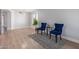 Bright living room featuring hardwood floors, stylish blue chairs, and a modern light fixture at 852 E Mountain View Rd # 18, San Tan Valley, AZ 85143