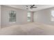 Large bedroom with ceiling fan, neutral carpet, plenty of natural light from numerous windows at 852 E Mountain View Rd # 18, San Tan Valley, AZ 85143