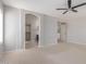 Main bedroom with large walk-in closet, arched doorway, ceiling fan, and neutral carpet at 852 E Mountain View Rd # 18, San Tan Valley, AZ 85143