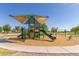 A vibrant community playground with modern equipment, including swings, a slide, and a covered play area at 852 E Mountain View Rd # 18, San Tan Valley, AZ 85143