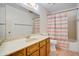 Bathroom featuring a large mirror, wooden vanity, toilet and tub with striped shower curtain at 858 S Portland --, Mesa, AZ 85206