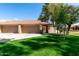 Home's exterior showcases a beautiful lawn, mature trees, and a driveway leading to the attached garages at 945 N Pasadena -- # 62, Mesa, AZ 85201