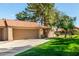 Exterior view of a one-story home featuring a two-car garage, desert landscaping, and a tile roof at 945 N Pasadena -- # 62, Mesa, AZ 85201