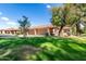 Well-maintained front yard with lush lawn and mature trees providing shade and curb appeal to the home at 945 N Pasadena -- # 62, Mesa, AZ 85201