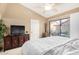 Bright main bedroom featuring a ceiling fan, an entertainment center and sliding glass door to the backyard at 945 N Pasadena -- # 62, Mesa, AZ 85201