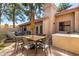 Charming outdoor patio with table, seating, and gas grill under mature trees at 945 N Pasadena -- # 62, Mesa, AZ 85201