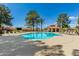 Community pool surrounded by trees, lounge chairs and a covered ramada at 945 N Pasadena -- # 62, Mesa, AZ 85201