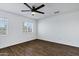 Spacious bedroom with wood-style tile floors, ceiling fan, and lots of natural light at 9522 E Quarterline Rd, Mesa, AZ 85207