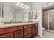 Bathroom with dual vanities, granite countertop, framed mirrors, and walk-in shower at 9550 E Thunderbird Rd # 149, Scottsdale, AZ 85260