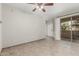 Bright living room with ceiling fan, tile floors, neutral walls, and a sliding glass door to the balcony at 9550 E Thunderbird Rd # 149, Scottsdale, AZ 85260