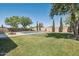 Manicured backyard featuring a sparkling pool, lush lawn, and decorative landscaping for outdoor enjoyment at 9570 W Quail Track Dr, Peoria, AZ 85383