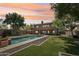Spacious backyard with a pool, lush lawn, and an inviting patio area at 9570 W Quail Track Dr, Peoria, AZ 85383