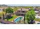 Stunning backyard with a sparkling pool, lush landscaping, and a charming patio area with fire pit at 9570 W Quail Track Dr, Peoria, AZ 85383