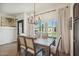 A dining area features a rustic wood table, backyard views, and modern chandelier at 9570 W Quail Track Dr, Peoria, AZ 85383