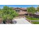 Beautiful two-story home with a three-car garage and green lawn is framed by lush trees at 9570 W Quail Track Dr, Peoria, AZ 85383