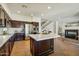 A stylish kitchen features stainless steel appliances, dark cabinetry, and an island with a sink and countertop at 9570 W Quail Track Dr, Peoria, AZ 85383