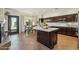 An open kitchen features dark wood cabinetry, a large island, and an adjacent dining area with backyard view at 9570 W Quail Track Dr, Peoria, AZ 85383