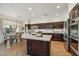 A bright kitchen features dark wood cabinets, a central island, and stainless steel appliances at 9570 W Quail Track Dr, Peoria, AZ 85383