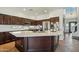 A modern kitchen features dark wood cabinets, a central island, and stainless steel appliances at 9570 W Quail Track Dr, Peoria, AZ 85383