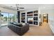 Open concept living room features balcony access, custom built-in shelving, and a modern aesthetic at 9570 W Quail Track Dr, Peoria, AZ 85383