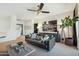 Cozy living room with a black leather sofa, patterned pillows, and modern light fixtures at 9570 W Quail Track Dr, Peoria, AZ 85383