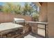 Well-equipped outdoor kitchen area with a built-in grill, sink, refrigerator, and stone accents at 9570 W Quail Track Dr, Peoria, AZ 85383