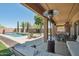 Inviting covered patio with an outdoor kitchen, dining area, and lounge space overlooking the pool at 9570 W Quail Track Dr, Peoria, AZ 85383