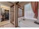 Bathroom featuring walk-in shower with tile surround and bathtub near obscured glass window at 9642 E Irwin Ave, Mesa, AZ 85209