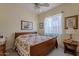 Bedroom features ceiling fan, floral bedding, matching side tables, and decorative framed art at 9642 E Irwin Ave, Mesa, AZ 85209