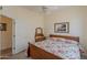Bedroom features floral bedding, ceiling fan, natural light, and wood furnishings at 9642 E Irwin Ave, Mesa, AZ 85209