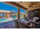 Inviting covered patio with cozy seating area overlooking pool and backyard oasis at 9642 E Irwin Ave, Mesa, AZ 85209