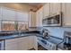 Updated kitchen with stainless steel appliances, white cabinets, granite counters, and white subway tile backsplash at 9642 E Irwin Ave, Mesa, AZ 85209