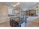 Spacious kitchen featuring white cabinets, granite counters, island, and breakfast bar open to the living area at 9642 E Irwin Ave, Mesa, AZ 85209